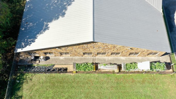 Aerial view of a building with a landscaped garden area beside it.